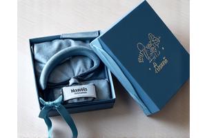 Nicely wrapped gift box with a personalized dog collar inside, on a clean background.